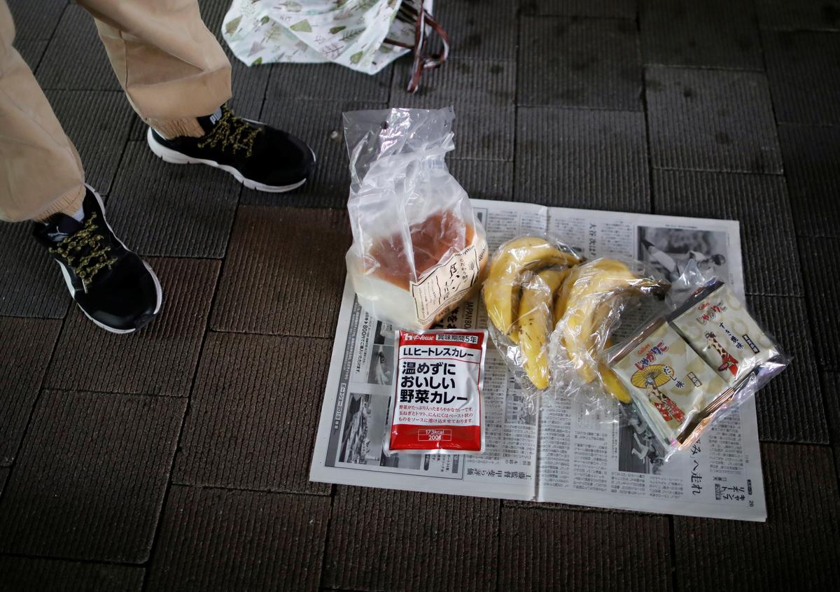An elderly man who lost his stable job caused by the impacts of the coronavirus disease (COVID-19) outbreak, shows off foods which he received at food aid handouts for the needy, in Tokyo, Japan, May 9, 2020. Photo: Reuters