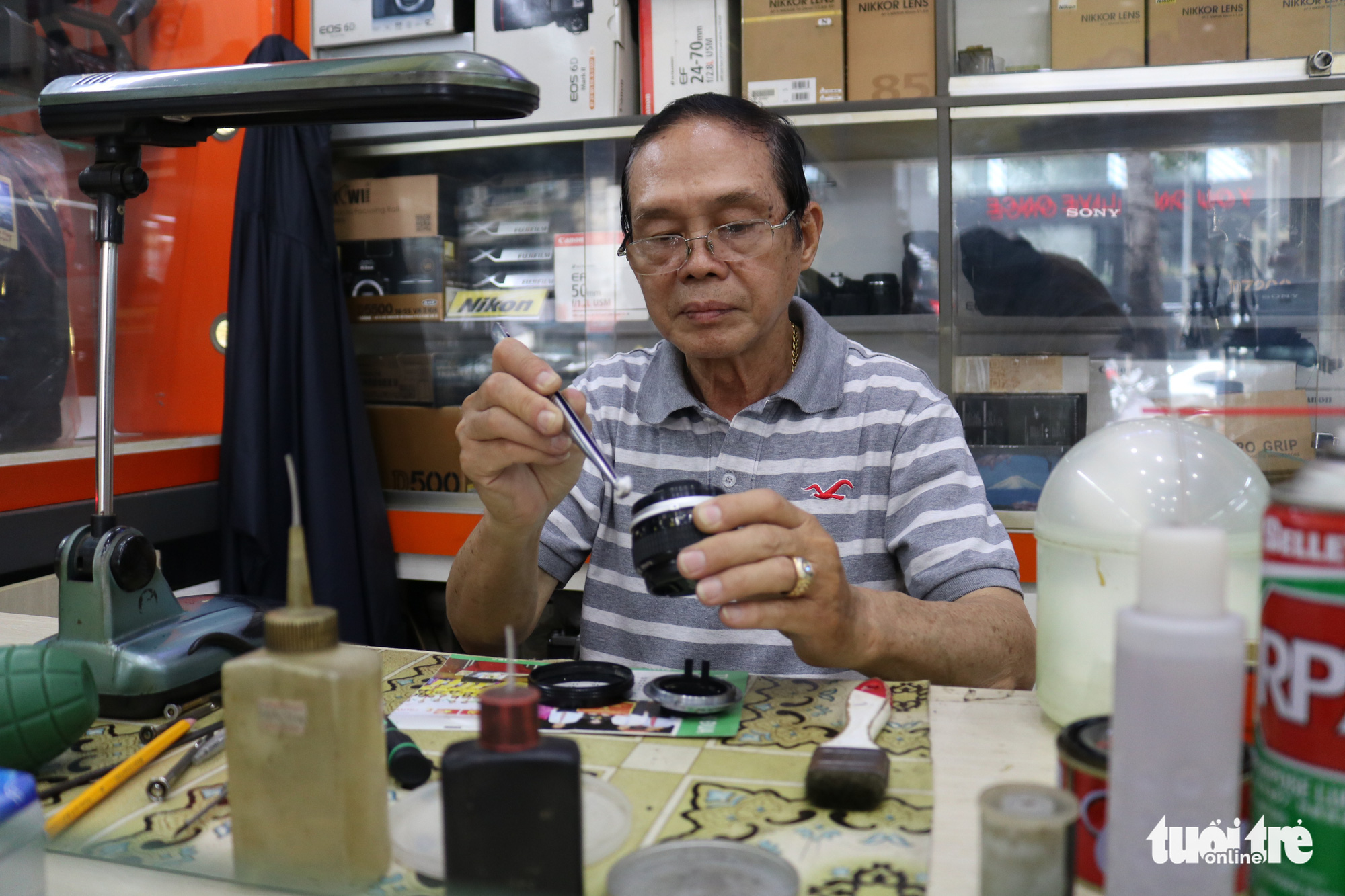 Every day, Nguyen Van Tan travels from his home in District 10 to a camera shop in District 1 to do his job. Photo: Ngoc Phuong/ Tuoi Tre