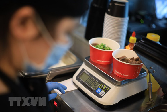 An attendant weighs two bowls of Phoinmoscow’s pho. Photo: Vietnam News Agency