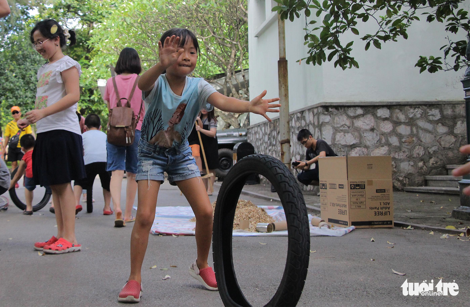A girl plays with an old tire at the ‘Kingdom of Recycled Materials’ event in Hanoi, Vietnam, May 31, 2020. Photo: Ha Thanh / Tuoi Tre