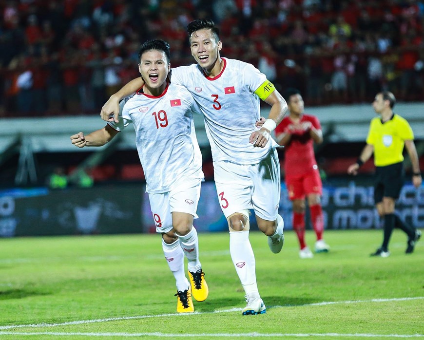 Attacking midfielder Nguyen Quang Hai (left) and defender Que Ngoc Hai react after the latter scores the second goal for Vietnam at a World Cup qualifier against hosts Indonesia in Bali, October 15, 2019. Photo: Vietnam News Agency