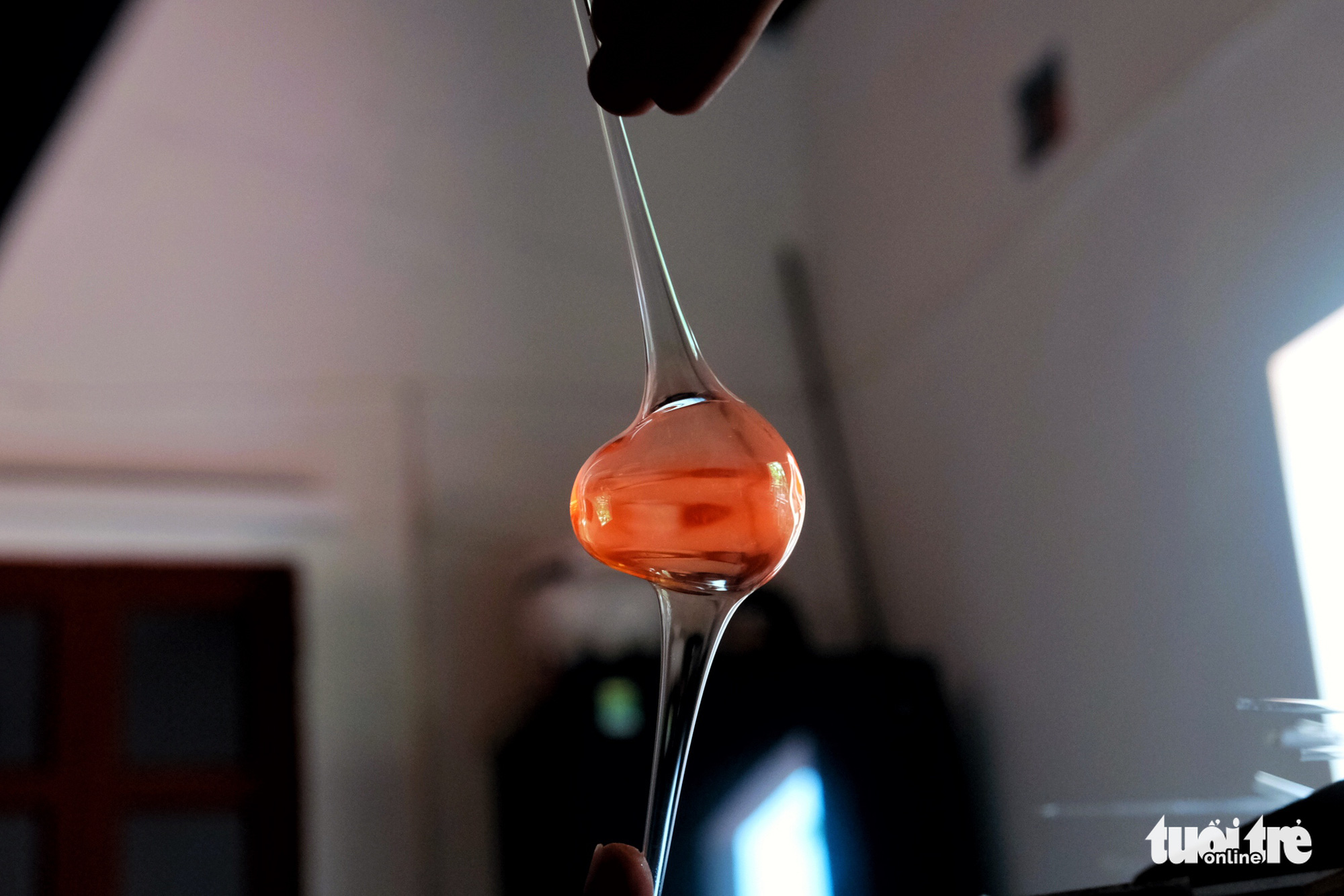A glass blower molds blobs of molten glass into products with uniform thickness. Photo: Mai Thuong / Tuoi Tre