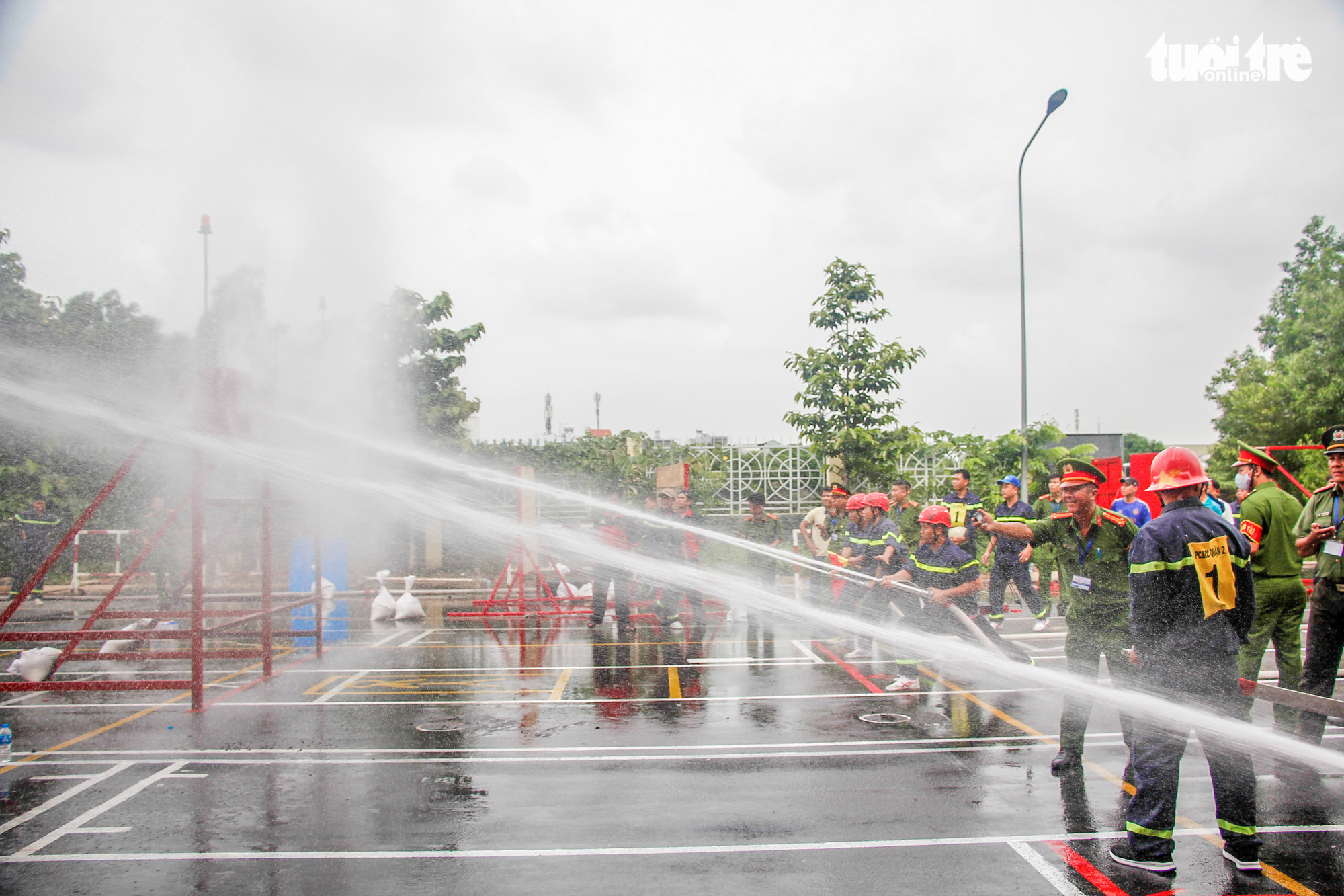 Firefighters use water hoses to put out fire during a firefighting and rescue competition in Ho Chi Minh City, June 16, 2020. Photo: Chau Tuan / Tuoi Tre