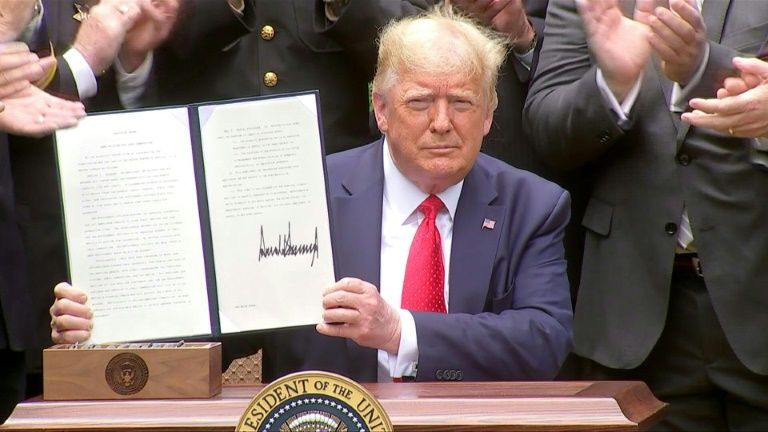 President Donald Trump signs an executive order on police reforms amid protests against police violence. Photo: AFP