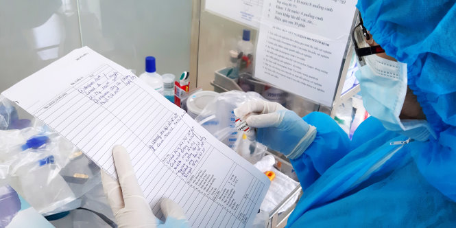 A health worker at Cho Ray Hospital in Ho Chi Minh City checks a medical note concerning a British man who is Vietnam’s novel coronavirus disease (COVID-19) patient No. 91, June 17, 2020. Photo: Duyen Phan / Tuoi Tre