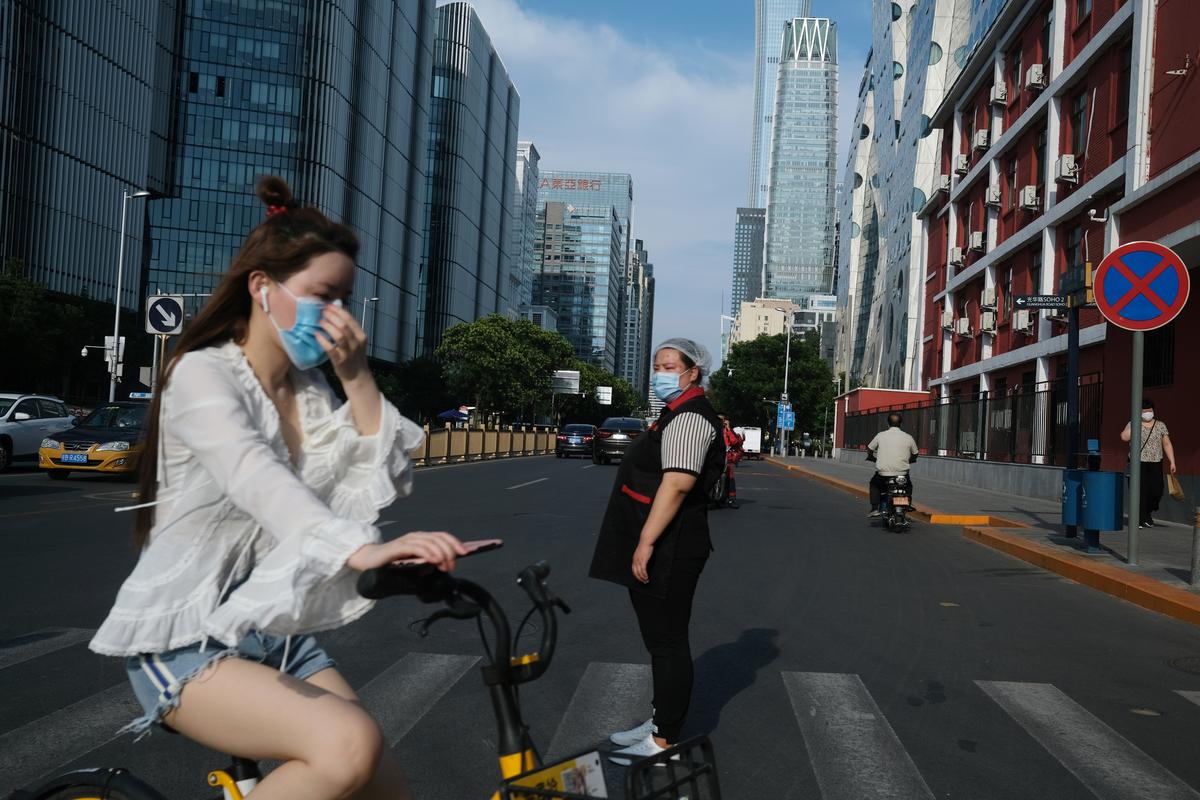 People wearing face masks cross a street, following the coronavirus disease (COVID-19) outbreak, in Beijing's central business area, China June 30, 2020. Photo: Reuters
