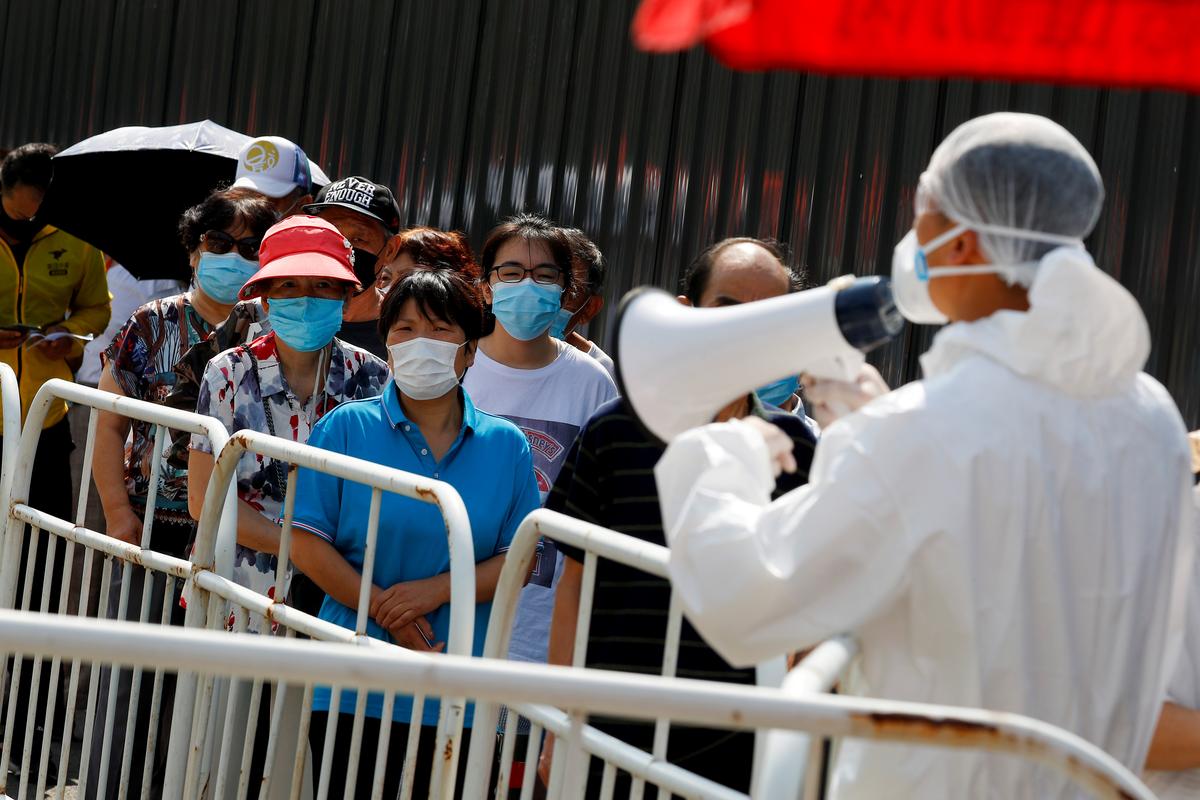 People line up to receive nucleic acid tests at a temporary testing site after a new outbreak of the coronavirus disease (COVID-19) in Beijing, China June 30, 2020.  Photo: Reuters