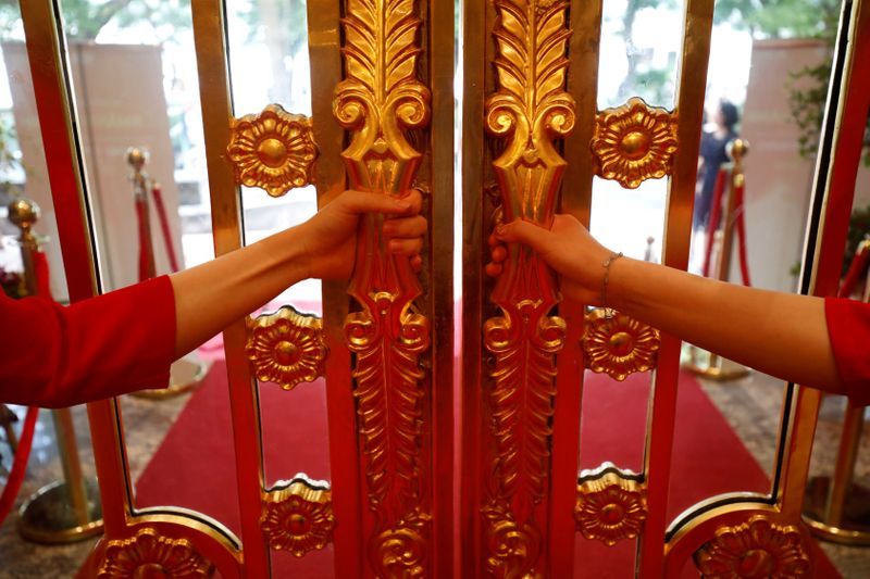 Staff members open the doors of the newly inaugurated Dolce Hanoi Golden Lake luxury hotel, which features gold-plated exteriors and interiors, after the government eased nationwide social distancing following the global outbreak of the coronavirus disease (COVID-19), in Hanoi, Vietnam. Photo: Reuters