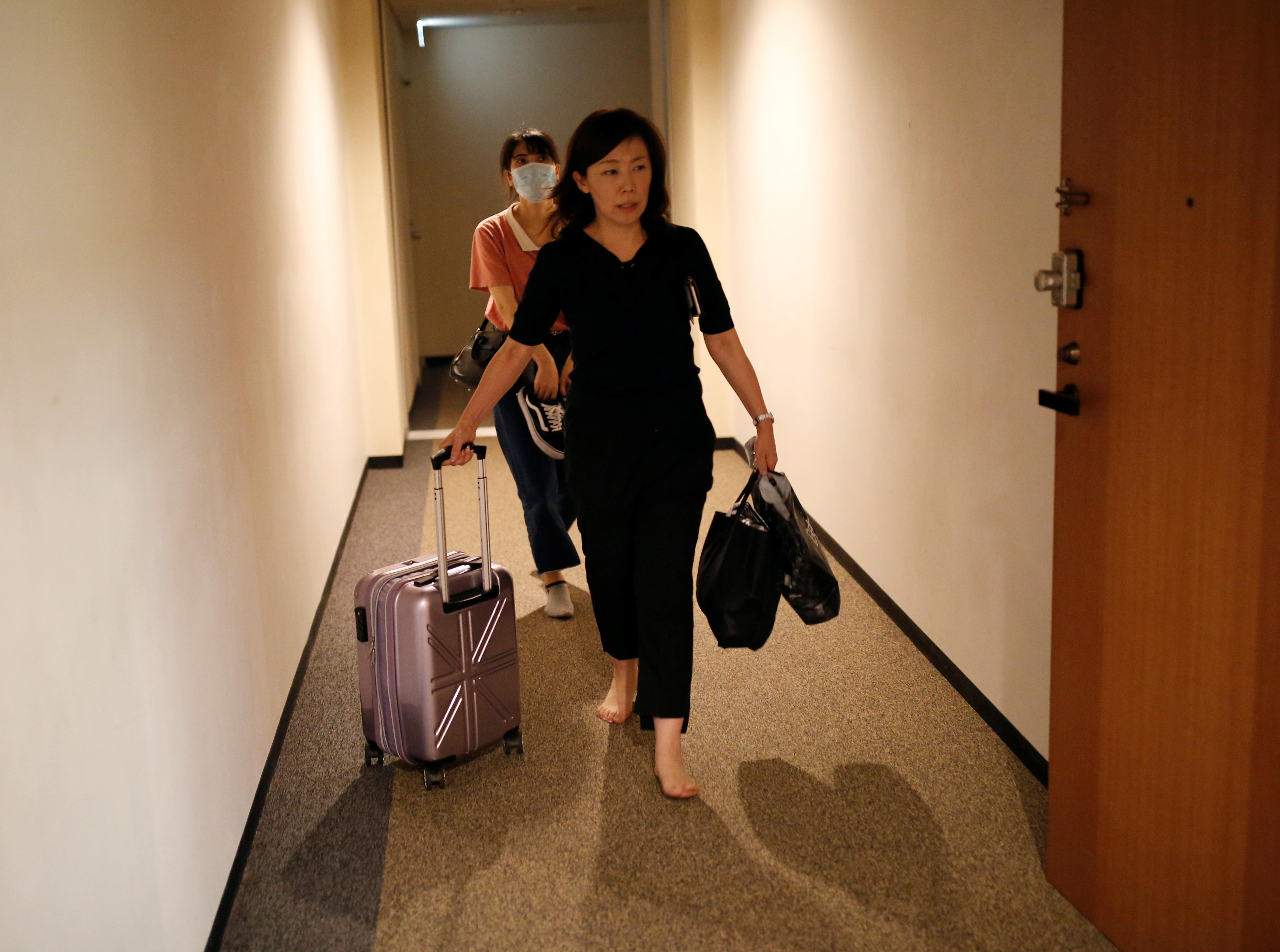 Jiho Yoshimizu helps Thi Tu Luong, a Vietnamese migrant worker who lost her job amid the coronavirus disease (COVID-19) outbreak, to enter a Buddhist temple which has turned into a shelter for young Vietnamese migrant workers in Tokyo, Japan, July 2, 2020. Photo: Reuters