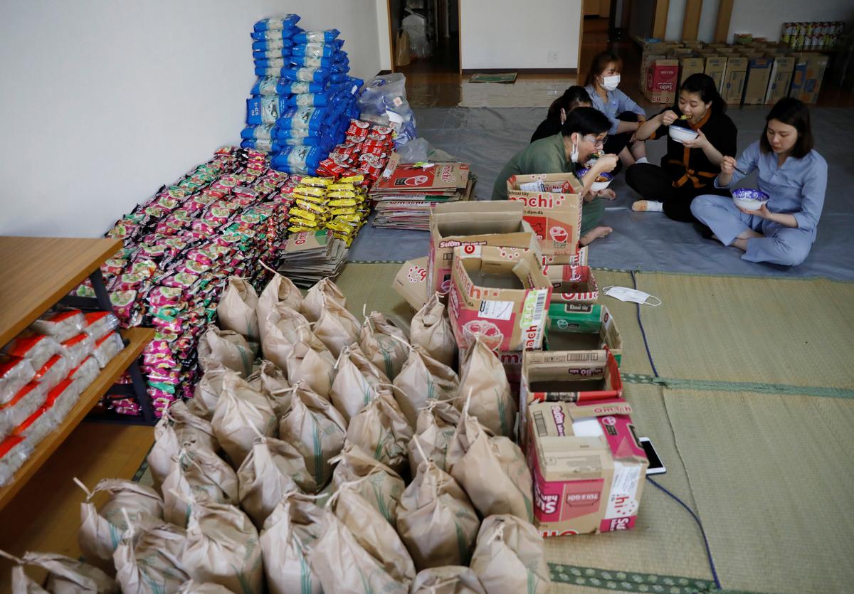 Vietnamese volunteers and migrant workers, who lost their jobs amid the coronavirus disease (COVID-19) outbreak, eat lunch during a break while they prepare packages of food and protective masks for Vietnamese people in need and living in Japan at a Buddhist temple which has turned into a shelter for young Vietnamese migrant workers in Tokyo, Japan, May 2, 2020. Photo: Reuters