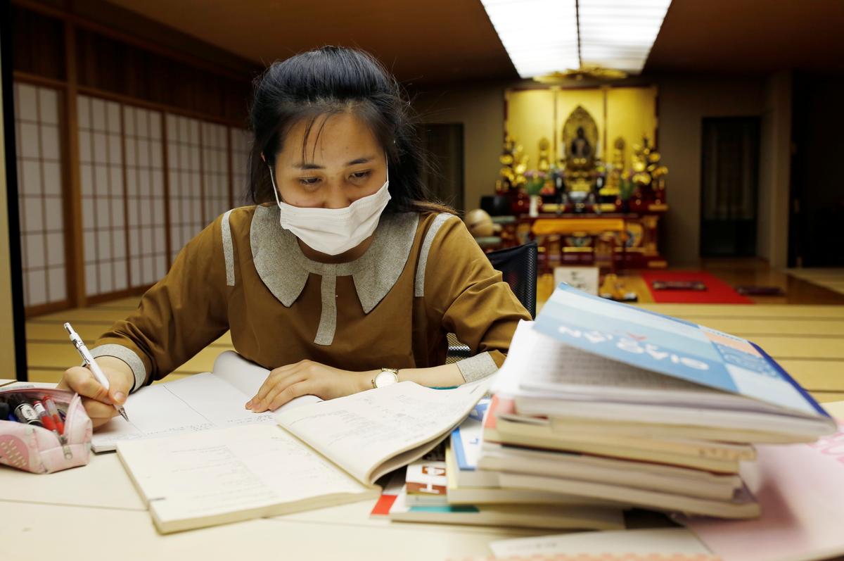 A Vietnamese migrant worker who lost her job amid the coronavirus disease (COVID-19) outbreak, studies Japanese language at a Buddhist temple which has turned into a shelter for young Vietnamese migrant workers in Tokyo, Japan, July 2, 2020. Photo: Reuters