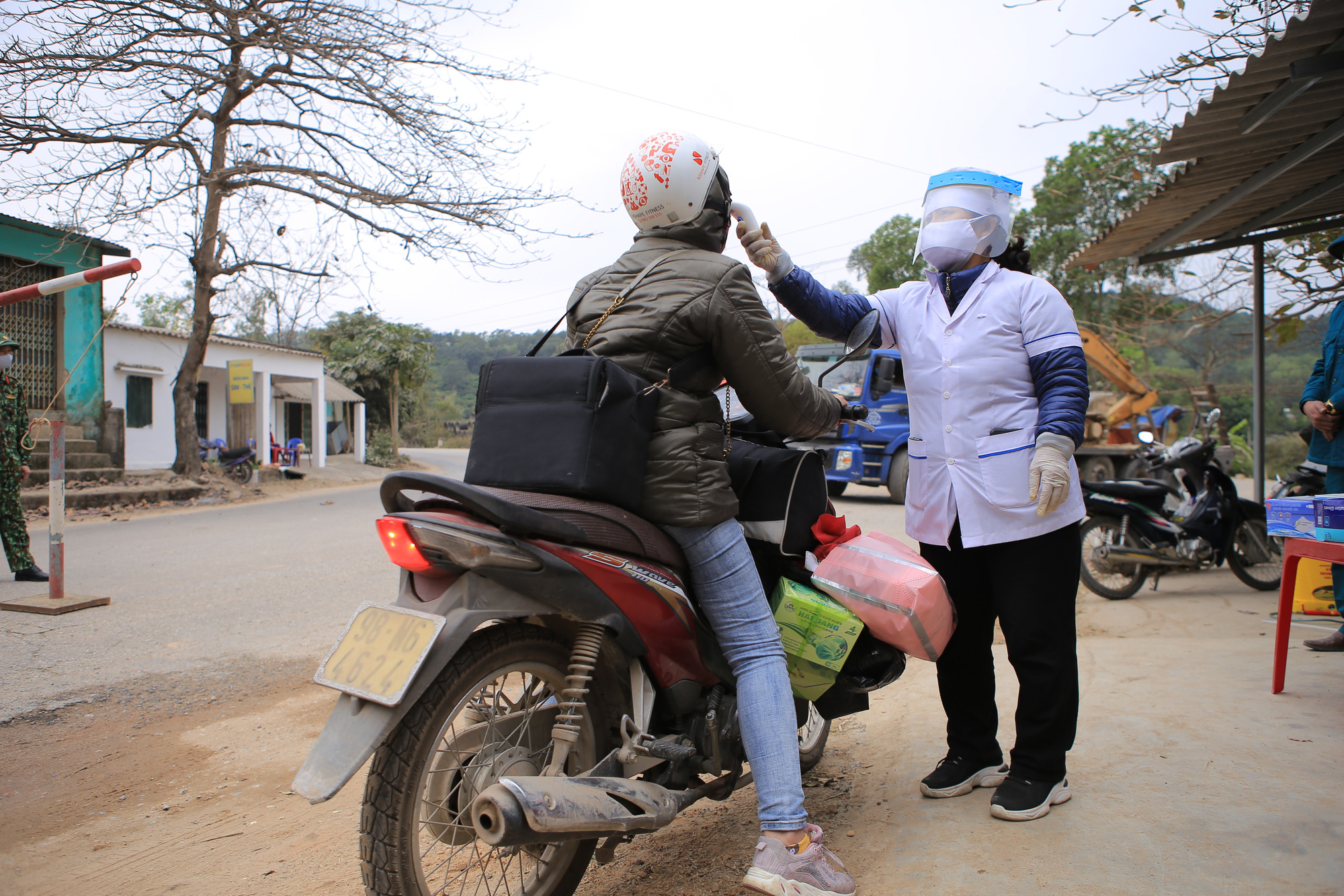 A resident has her body temperature measured at a COVID-19 checkpoint in Chi Linh City, Hai Duong Province, January 28, 2021. Photo: Anh Cuong / Tuoi Tre