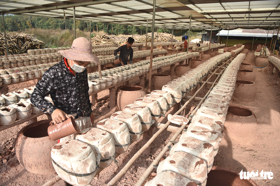 Workers pour clay into a buffalo mold at Tran Quoc Tuan’s workshop in Tan Uyen Town, Binh Duong Province. Photo: Ngoc Phuong / Tuoi Tre