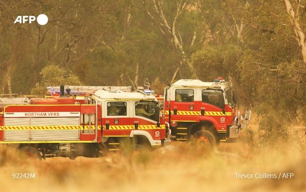 Fire trucks sit in a valley awaiting instructions as a fire burns on a ridge, driven by strong winds in the suburb of Brigadoon in Perth on February 2, 2021, just days after the west coast city entered a coronavirus lockdown. Photo: AFP