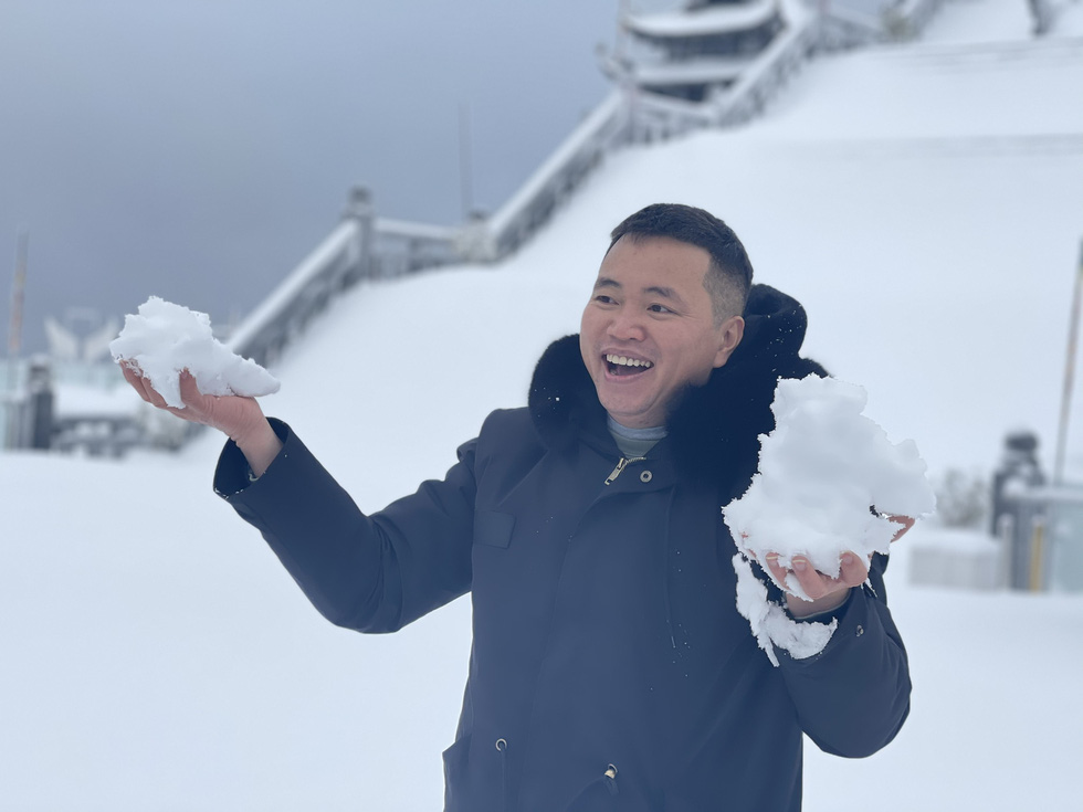 Nguyen Xuan Chien, director of the tourism complex Sun World Fansipan Legend, picks up snow on Mount Fansipan, February 9, 2021. Photo: To Ba Hieu / Tuoi Tre