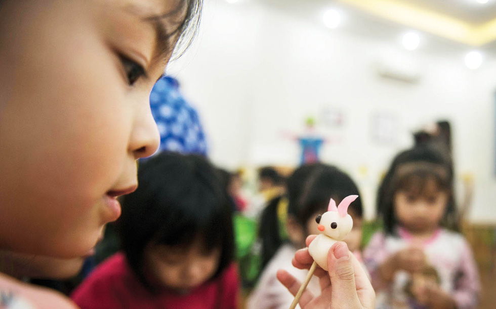 With Nguyen Van Thanh’s instructions, preschoolers manage to make eye-catching toy figurines during the captivating sessions. Photo: Hoang Ngoc Thach / Tuoi Tre