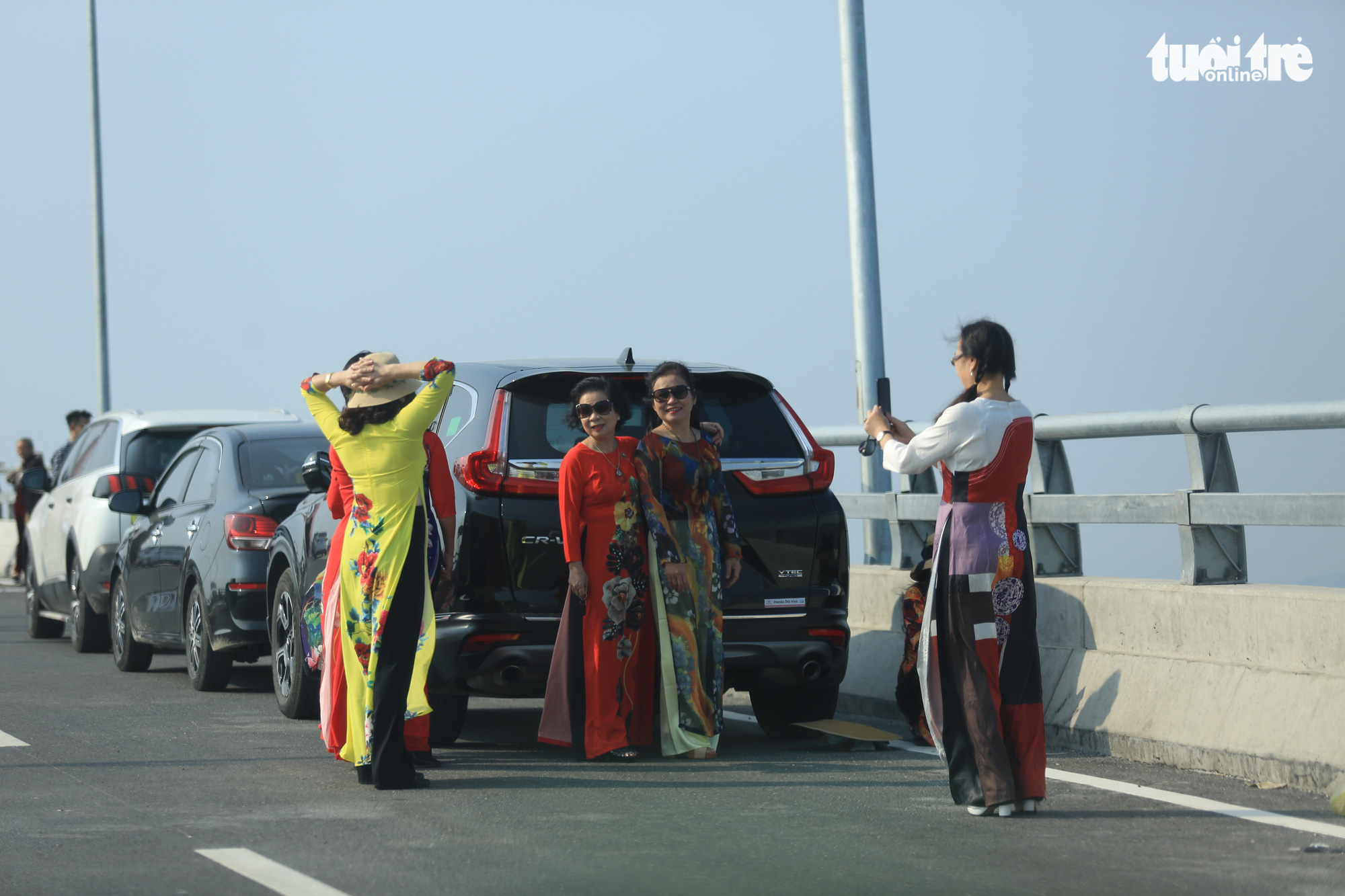 A group of women illegally stop their car to take photos on the Cua Hoi Bridge in north-central Vietnam, February 15, 2021. Photo: Ngoc Thang / Tuoi Tre