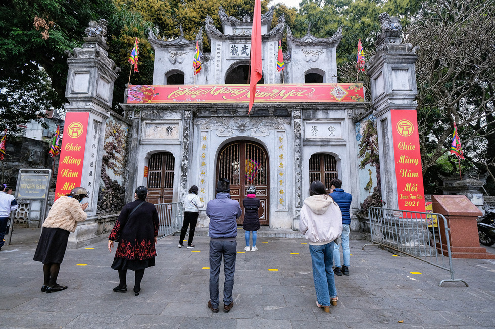 Pilgrims gather outside of the shuttered Quan Thanh temple in Tay Ho District for prayers, February 16, 2021. Photo: Nam Tran / Tuoi Tre