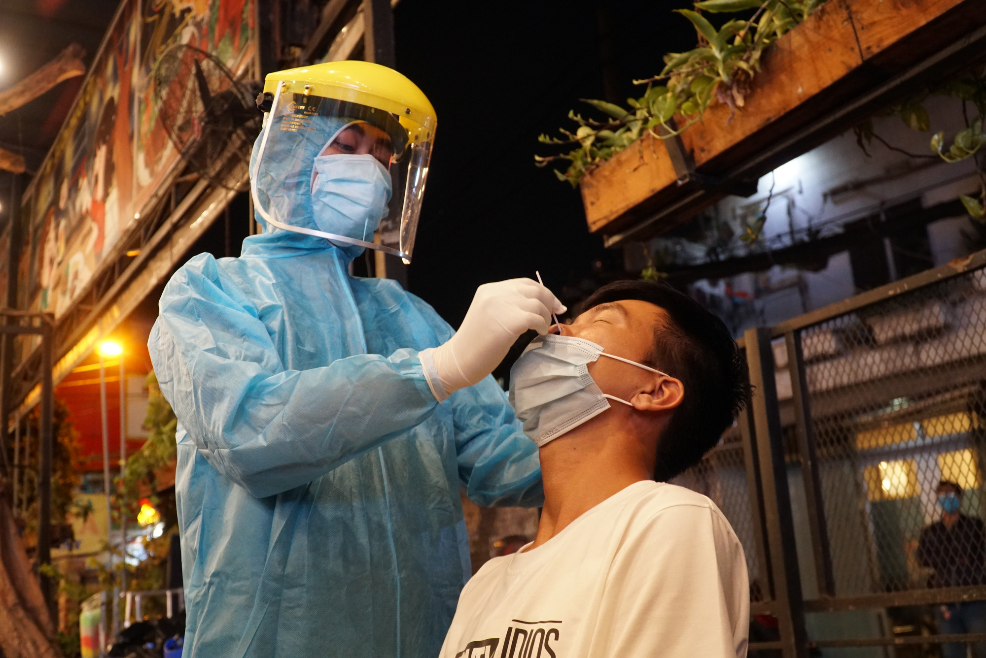 A medical worker samples a man at a restaurant in Ward 11, Binh Thanh District, Ho Chi Minh City, February 22, 2021. Photo: Dan Thuan / Tuoi Tre