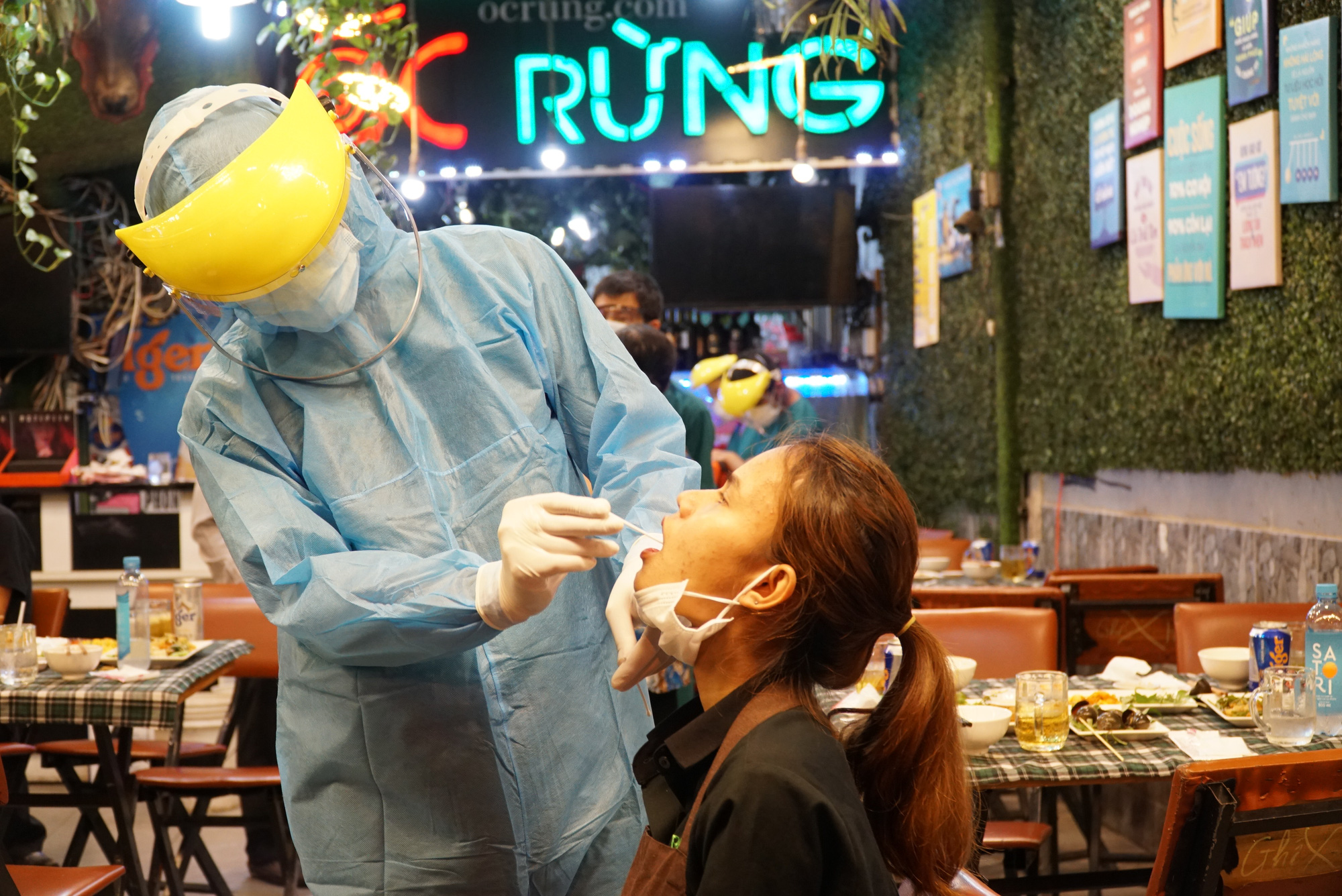 A medical worker samples a woman at a restaurant in Ward 11, Binh Thanh District, Ho Chi Minh City, February 22, 2021. Photo: Dan Thuan / Tuoi Tre