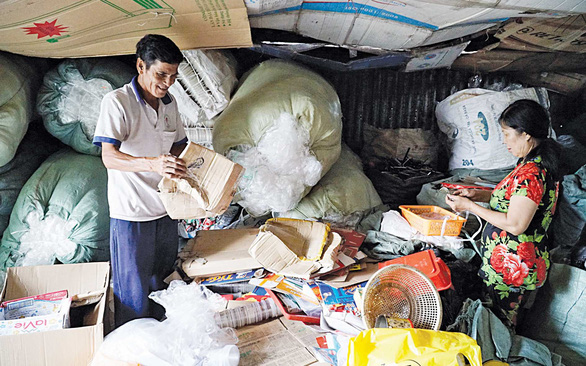 Long and his wife on the mezzanine of their house among their daily haul of recyclables. Photo: Ngoc Tai / Tuoi Tre