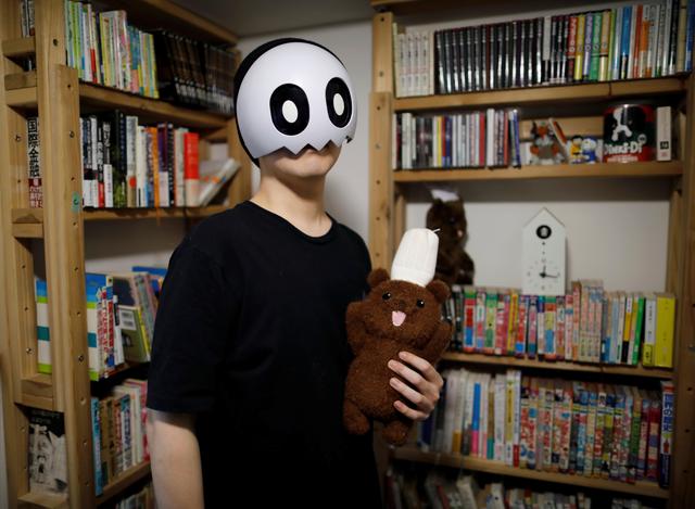 Japanese manga artist Kamentotsu, who goes by his pen name and wears a mask in media appearances, poses for a photograph at his workspace in Tokyo, Japan October 8, 2020. Picture taken October 8, 2020.  Photo: Reuters