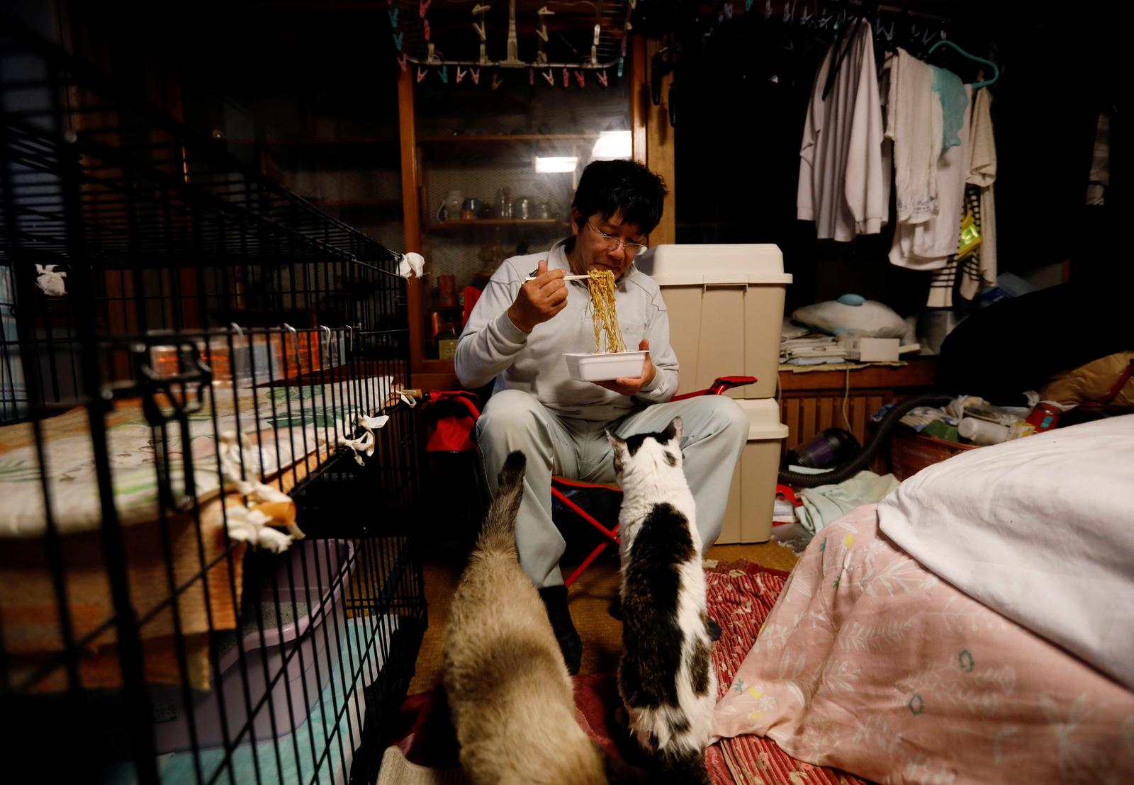 Sakae Kato eats instant noodles for dinner at his home in a restricted zone in Namie, Fukushima Prefecture, Japan, February 20, 2021. Photo: Reuters