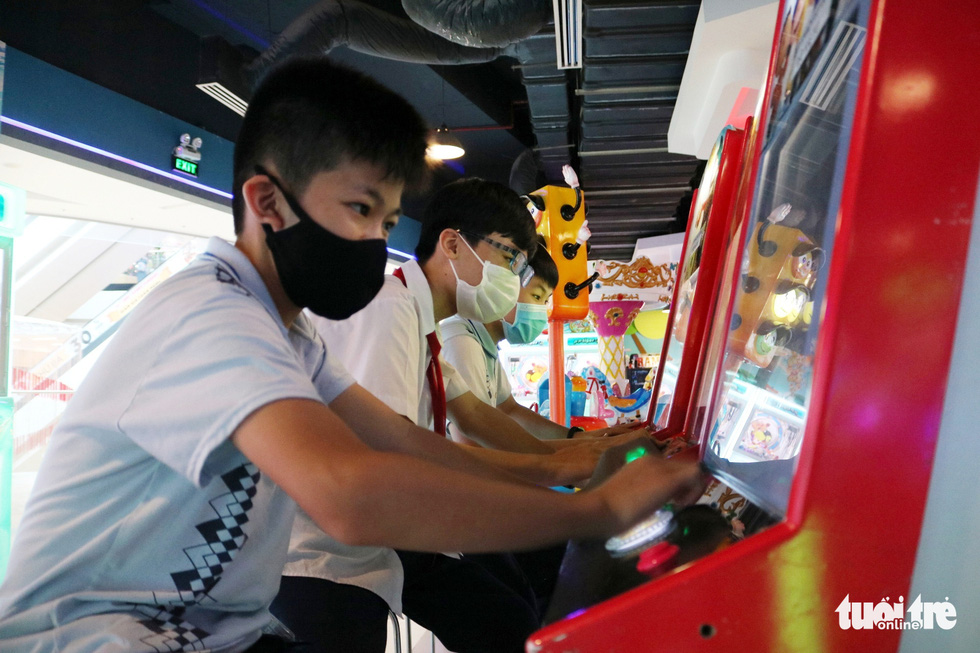 Children wearing face masks play games at a game center in Van Hanh Mall in District 10, Ho Chi Minh City, March 9, 2021. Photo: Nhat Thinh / Tuoi Tre