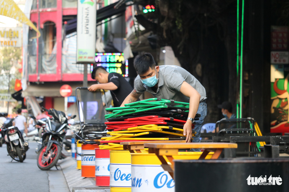 Workers arrange chairs at a drinking establishment on Bui Vien Street in District 1, Ho Chi Minh City, March 9, 2021. Photo: Nhat Thinh / Tuoi Tre