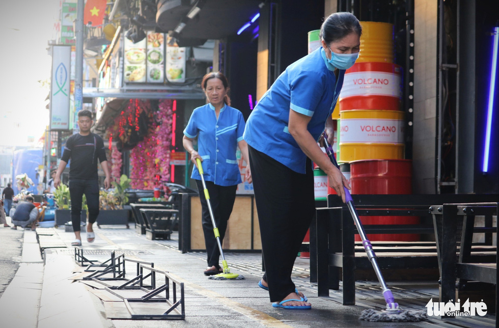 Workers clean the floor at a drinking establishment on Bui Vien Street in District 1, Ho Chi Minh City, March 9, 2021. Photo: Nhat Thinh / Tuoi Tre