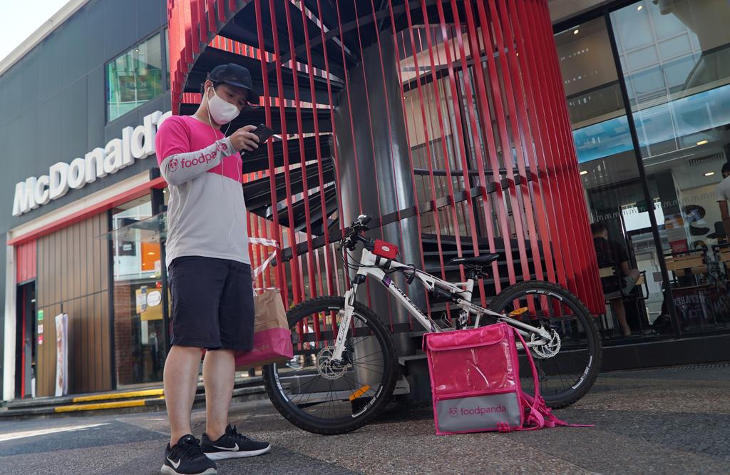 Classical orchestra conductor-turned food delivery driver, Chiya Amos, checks his phone before making a food delivery, amid the coronavirus disease (COVID-19) outbreak, in Singapore March 9, 2021. Photo: Reuters