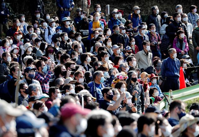 Visitors wearing protective masks, amid the coronavirus disease (COVID-19) outbreak, look at the fire-walking festival, called hiwatari matsuri in Japanese, at Mt.Takao in Tokyo, Japan, March 14, 2021. Photo: Reuters