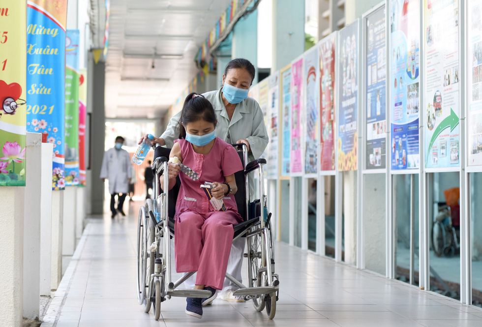 With her emaciated body weakened by the debilitating kidney disease, Nguyen Thi Nhu Tam sometimes resorts to a wheelchair and her mother’s assistance to get around. Photo: Duyen Phan / Tuoi Tre