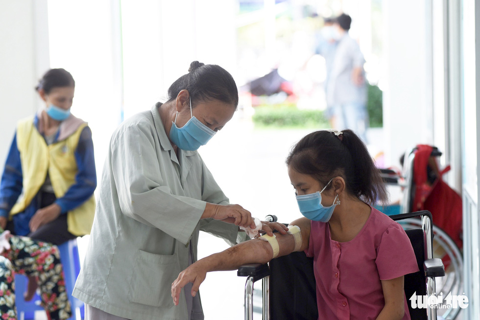 Tran Thi Ut (left) is always on standby to tend to her daughter after the dialysis sessions. Photo: Duyen Phan / Tuoi Tre